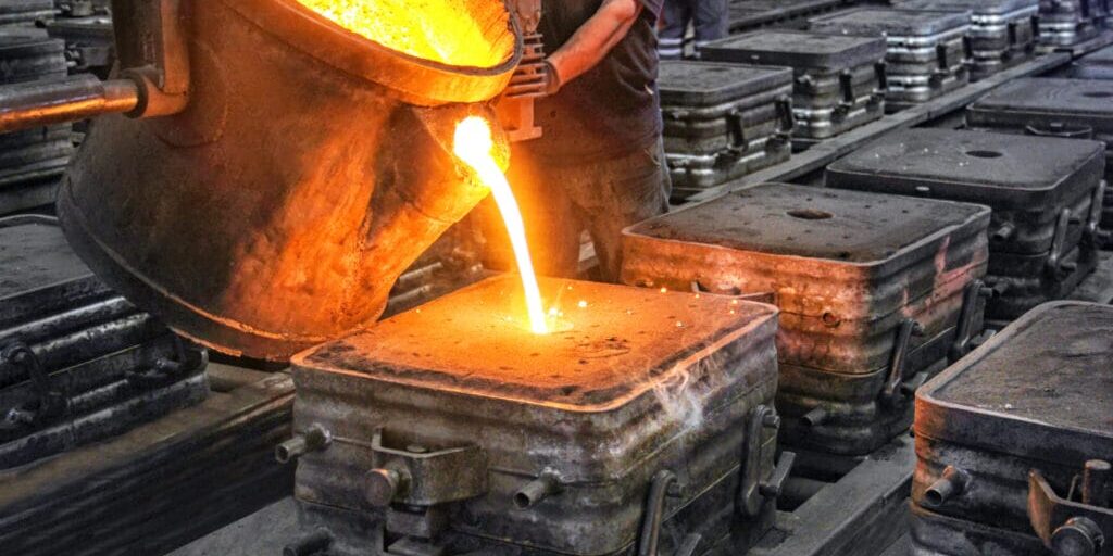 Molten metal poured from a ladle into molds on a foundry line, highlighting precision American manufacturing.